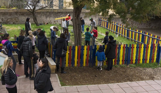 genitori e bambini che sistemano l'orto